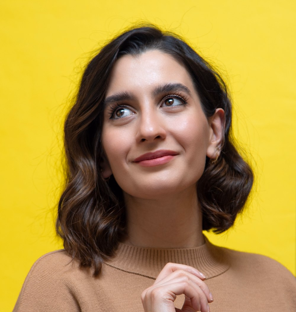 Testimonial portrait on a warm yellow studio backdrop